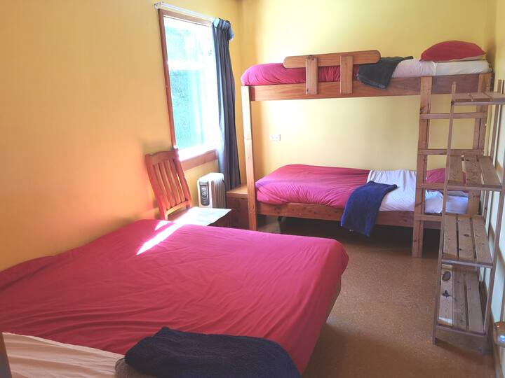 เตียงสองชั้นเสริมและเตียงควีนไซส์ในห้องนอน