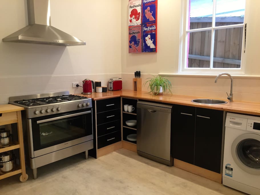 Modern kitchen equipped with gas cooking, dishwasher and washing machine