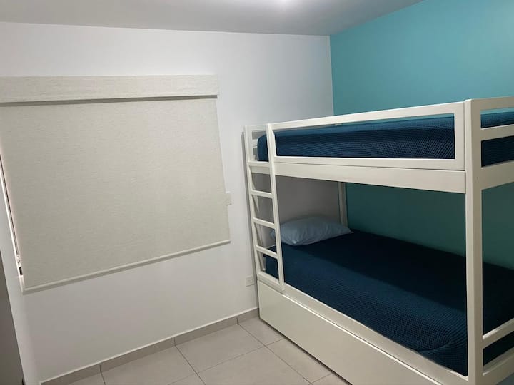 غرفة نوم بسرير بطابقين وخزانة ومكيف هواء