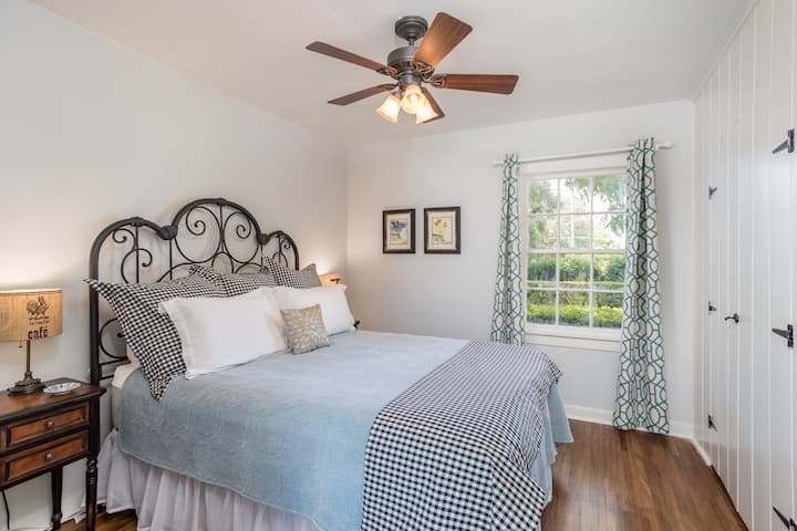 Third bedroom features an Iron headboard with Queen bed overlooking front courtyard.
