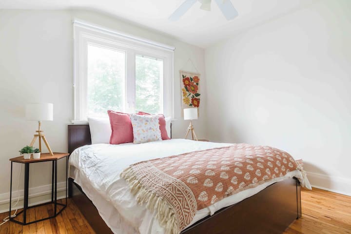 Პირველი საძინებელი სახლის წინა ნაწილში. Დედოფლის ზომის საწოლი საოფისე მაგიდით და საოფისე სკამით. 