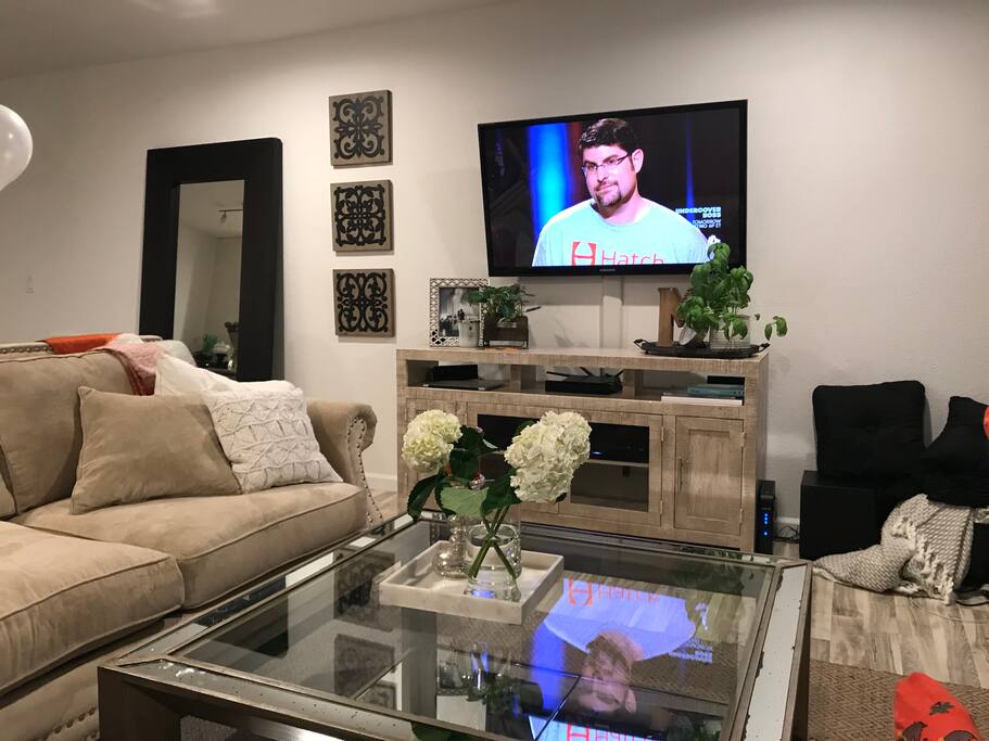 Living room area with 52" TV, surround sound speakers, Blu-Ray player, Cable TV, Large L Shaped Couch