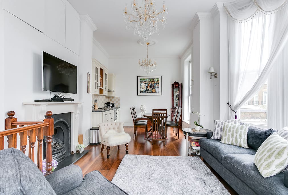 Overview of the entire living room with its dining space and flat screen tv