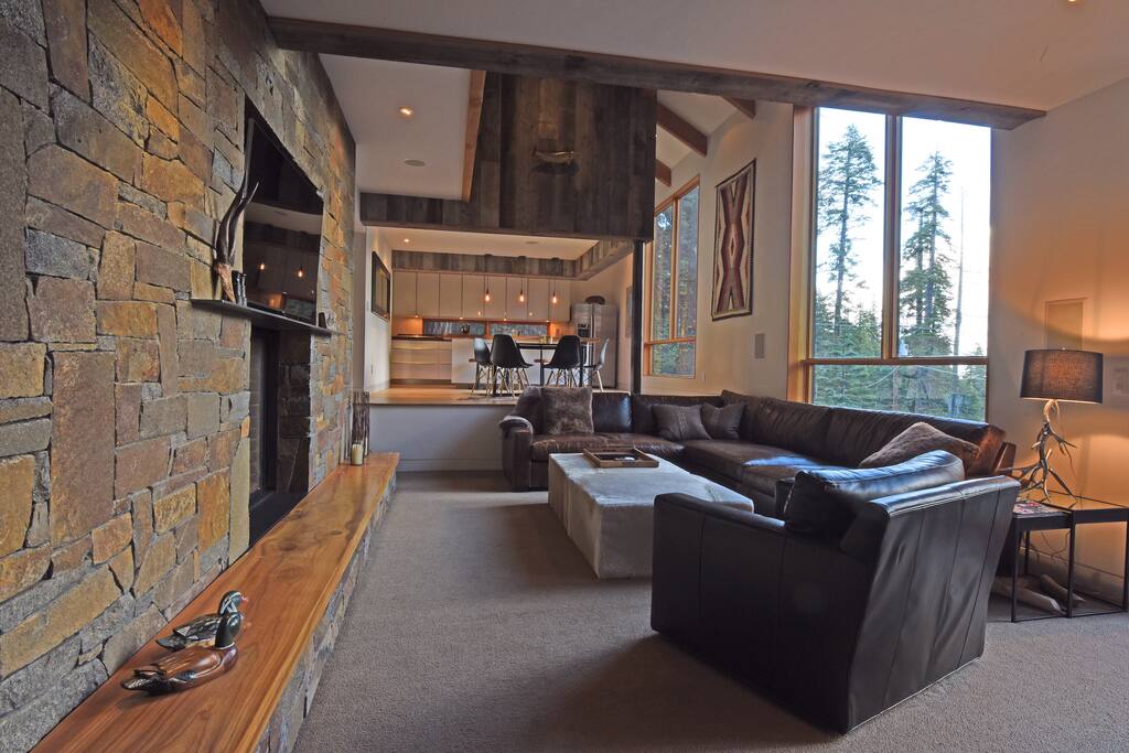 Beautifully designed living room with a fireplace, large TV, and open windows