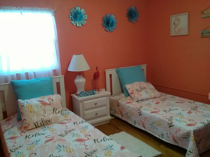 Habitación flamenca luminosa y caprichosa con camas individuales.