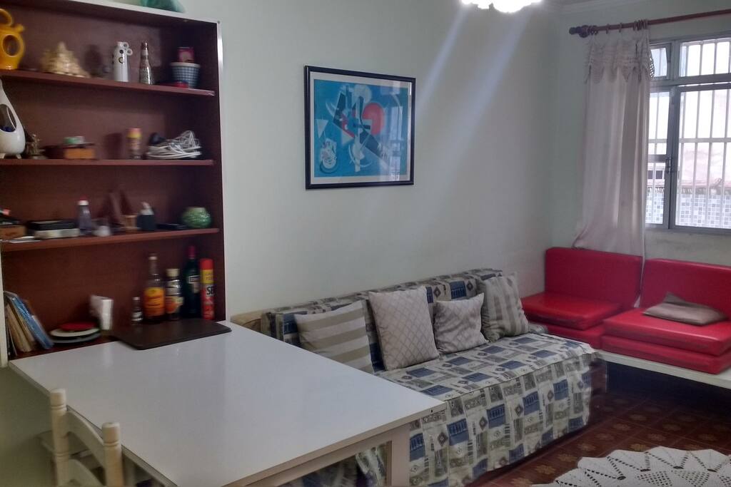 Sala com mesa ,sofa cama, TV e ventilador de teto
