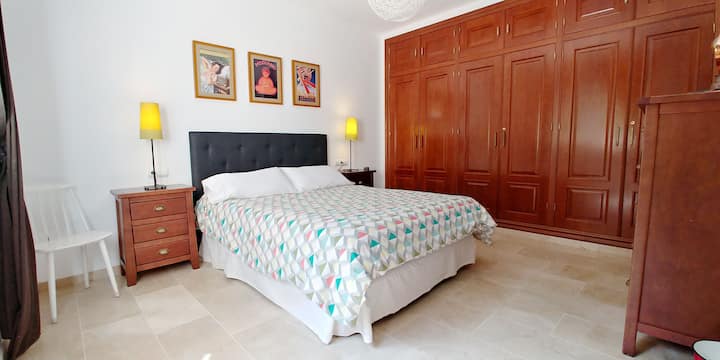 Dormitorio principal en la planta baja con cama king-size, armario, aire acondicionado y calefacción