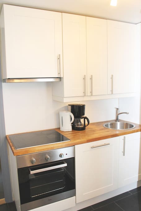 Small kitchen with fridge, dishwasher, stove, coffee maker etc.