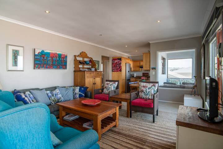 Sala de estar con vistas a la cocina y al área exterior del balcón.