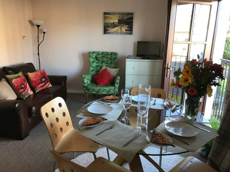 This is the living room with a dining table and TV. There are 2 bean bags in the corner for younger guests. There is a TV hooked up to BT TV, as well as regular TV. The flat has fiberoptic wifi. The sofa is also a fold down bed if guests require it.