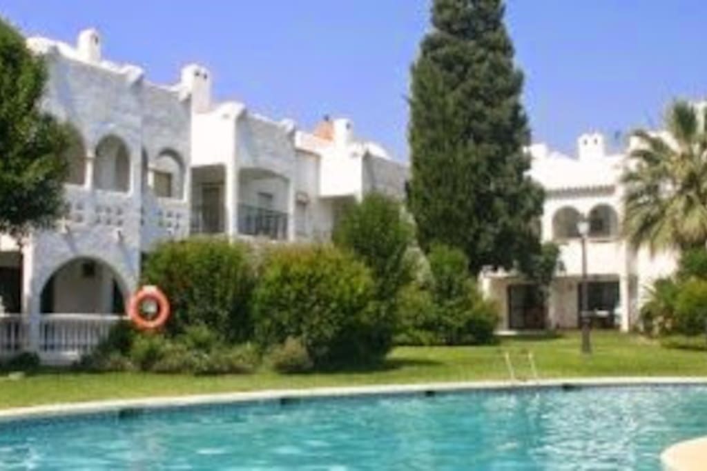 Entorno cesped y piscina.