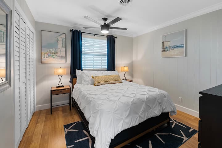 guest bedroom with smart tv, usb charging lamps, and cozy queen sized bed