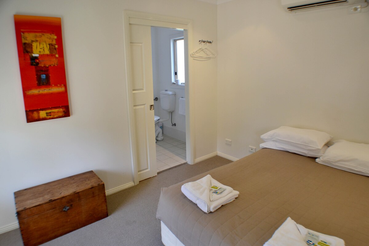 Удобна спална соба со двоен кревет кој води до голема бања погодна за лица со попреченост.