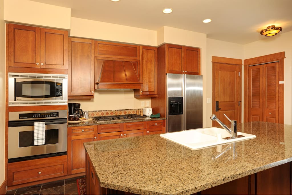 The fully-equipped kitchen features granite countertops and stainless steel appliances
