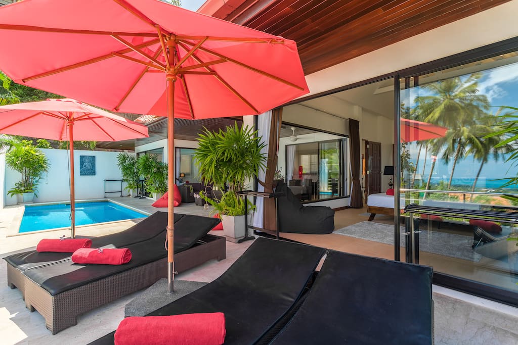 View of your villa with the reflection of the palm trees and the ocean in the large patio windows