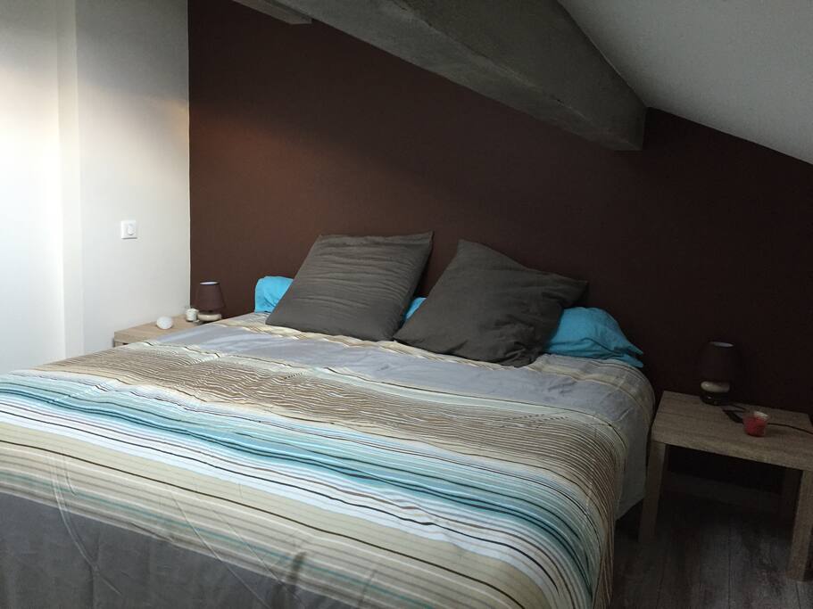 Chambre avec : 1 lit 180*200 cm, 2 tables de chevets avec lampes, placards, et commode avec miroir.