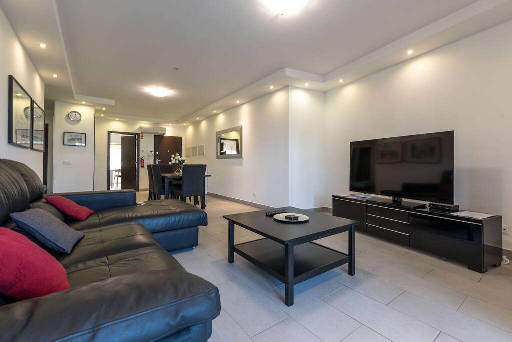 Big livingroom area with a big screen with cable TV