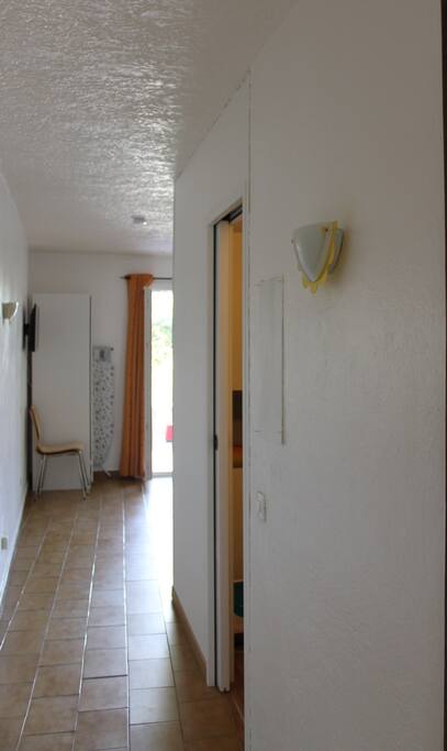 entrée couloir desservant la salle de bain, le coin chambre puis la pièce principale (cuisine - salon) et le balcon