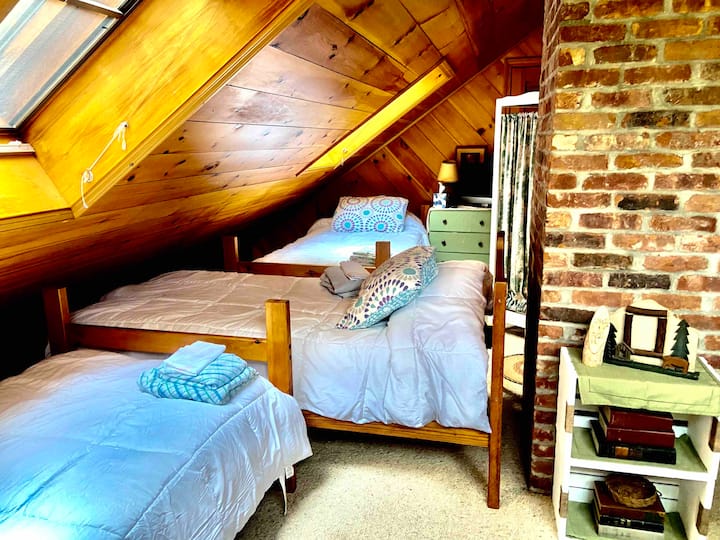 Loft - segundo piso - Necesito subir una escalera para llegar a estas acogedoras tres camas individuales. El loft tiene vistas a la sala de estar. 