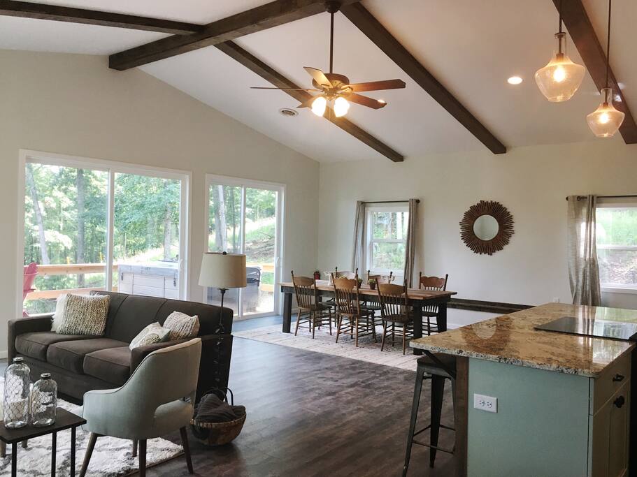 Open layout kitchen, dining room and living room with custom oversized sliding doors leading to the deck on two sides