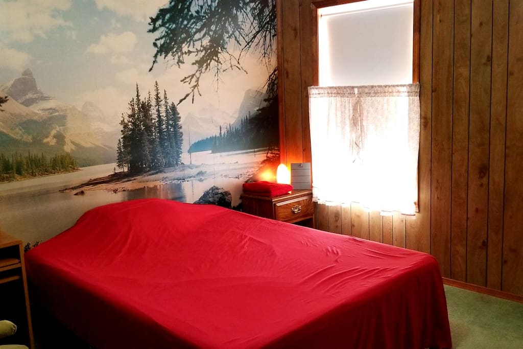 Queen Size bed w/memory foam mattress, lakeside mural, and nightstand w/pink Himalayan salt lamp.