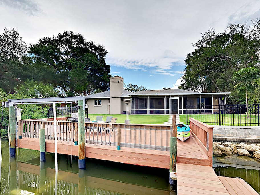 A gas grill and outdoor dining table on the sunny deck