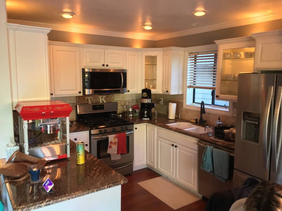 Kitchen with gas range, oven, microwave, coffee maker, toaster, and waffle maker