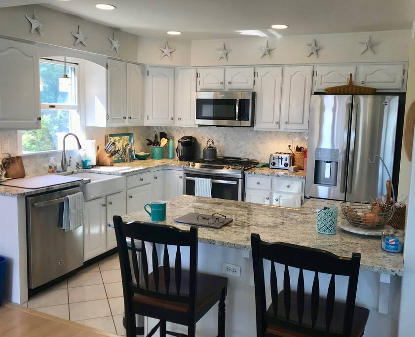 Kitchen w/granite counters, stainless appliances & farm sink.
