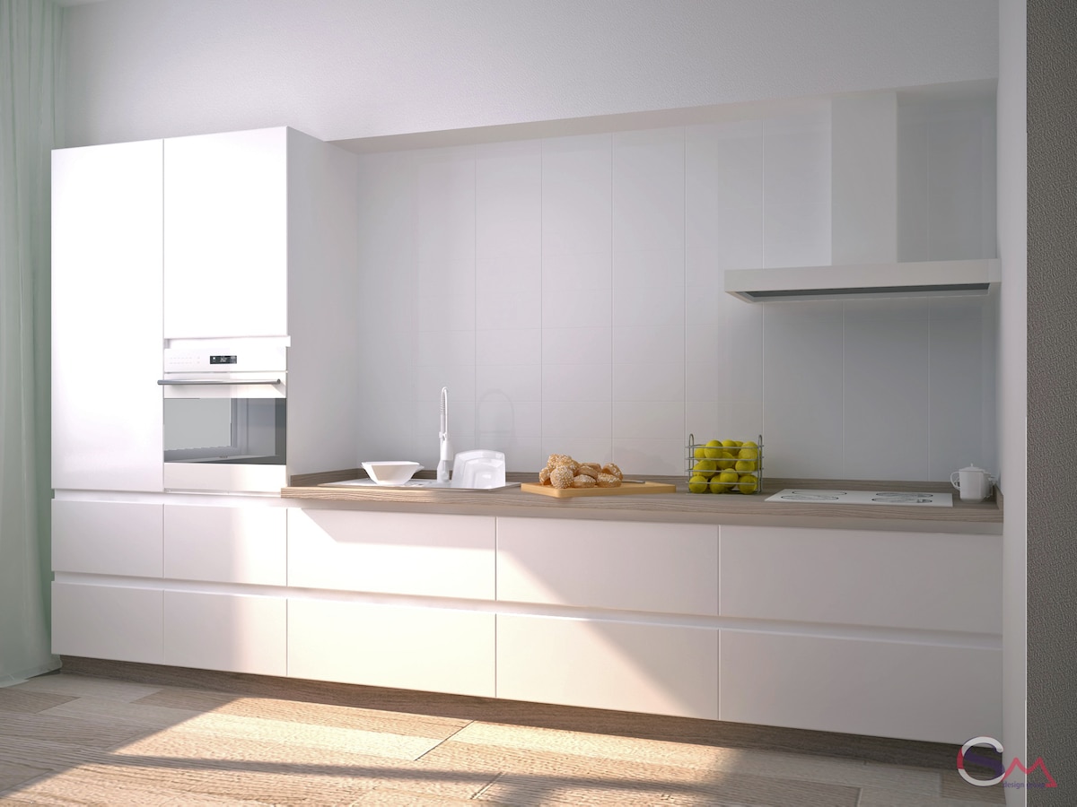 A modern kitchen is equipped with sleek white cabinetry and a light wood countertop. An oven is integrated into the cabinetry, while a clean layout highlights a bowl of yellow fruit. Natural light brightens the space through nearby windows.