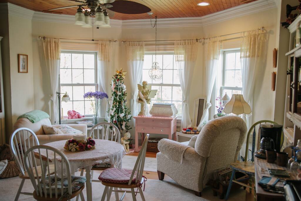 The common area includes a dining table, seating, and a daybed.