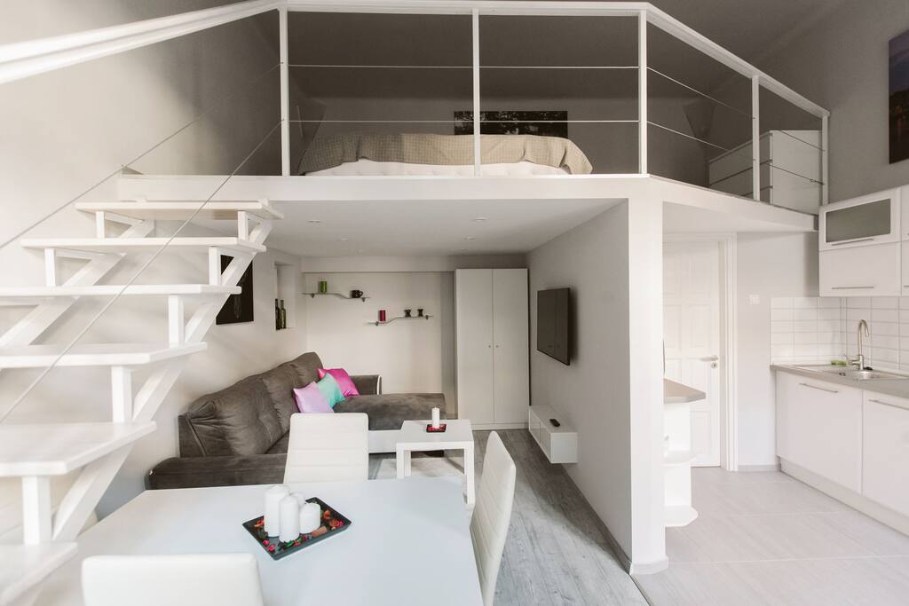 sleeping space on the mezzanine, living room and part of the kitchen with the entrance to the bathroom