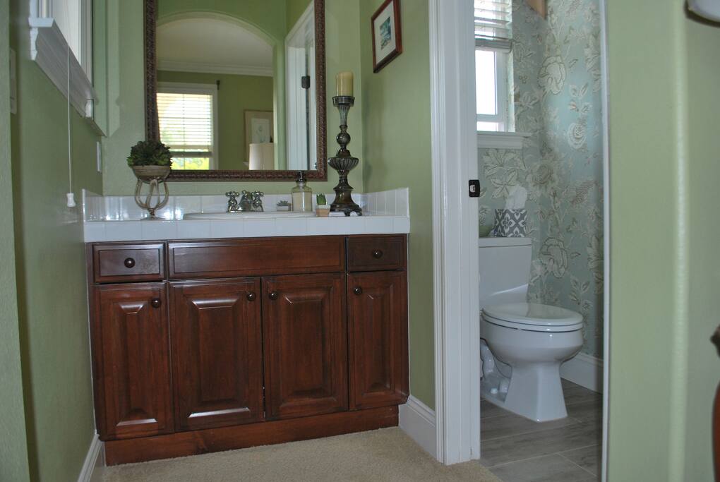 Private vanity with sink connected to bedroom #1. Adjacent to private bath with toilet, bathtub & shower. Stocked with linens, toiletries ,blow dryer and curling irons