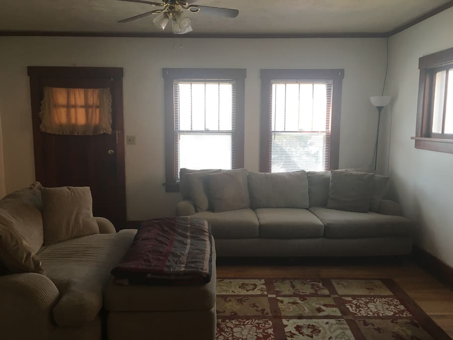 Living room area with couch & love seat with view to front porch.