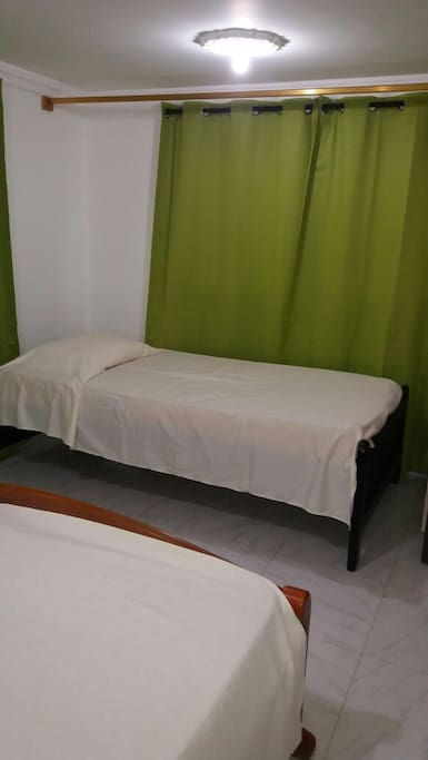 Una habitación con 2 camas una sencilla y una doble