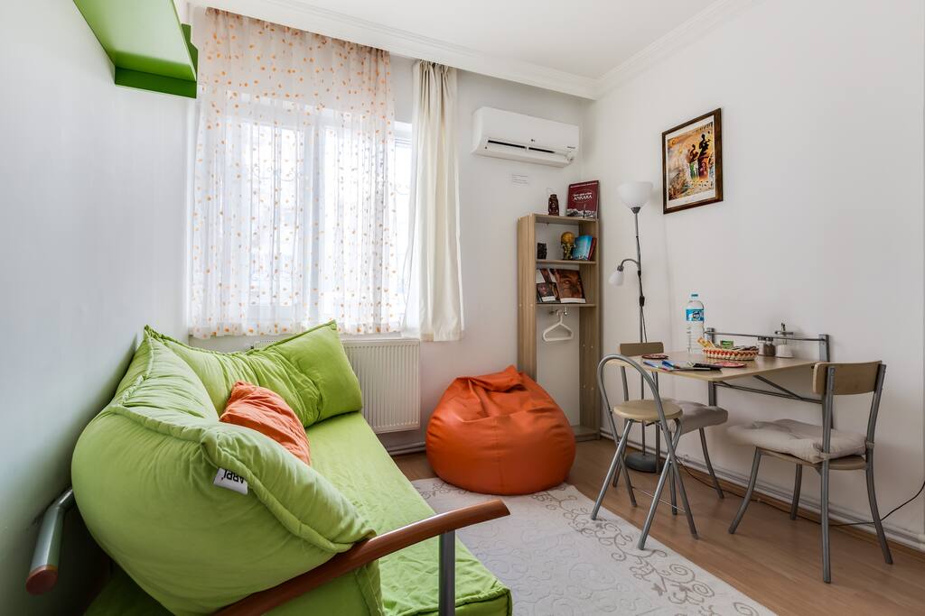 Primary living room; AC, sofa, bean bag chair and dining table. Sofa is adjustable as a comfortable single bed.