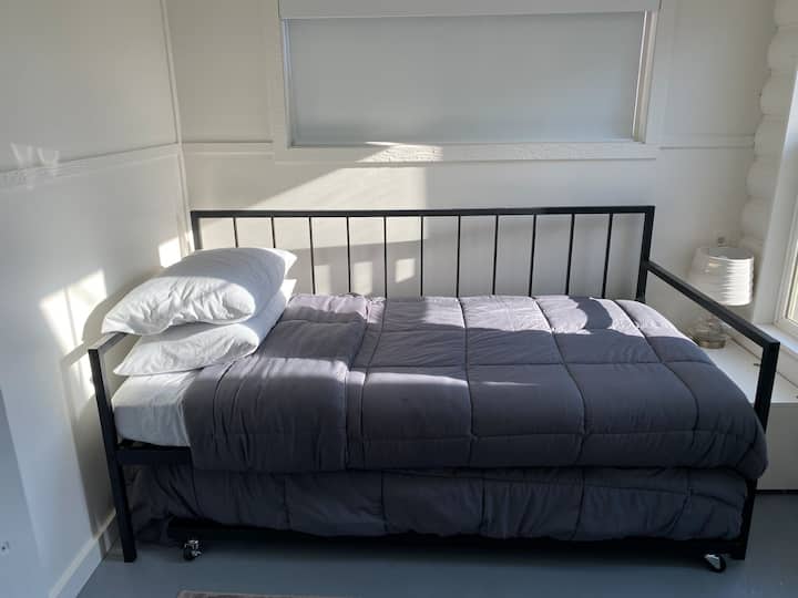 The 4th bedroom features a versatile trundle bed with two twin Aveline foam mattresses, ensuring a comfortable night's sleep. Black out blinds provide added comfort for guests of all ages. This room is designed with play in mind, offering toys/books.