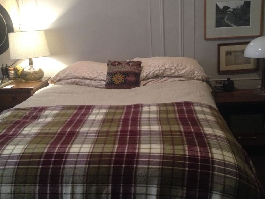 Private bedroom furnished with bed & desk.