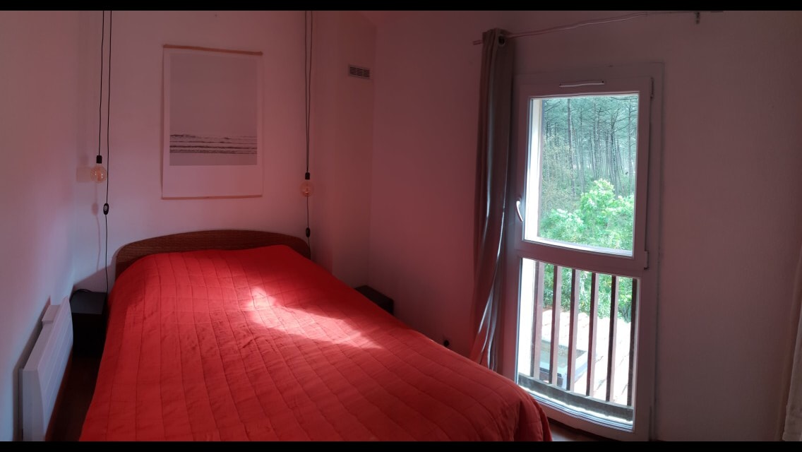 Bračni krevet u spavaćoj sobi s pogledom na šumu i spremištem