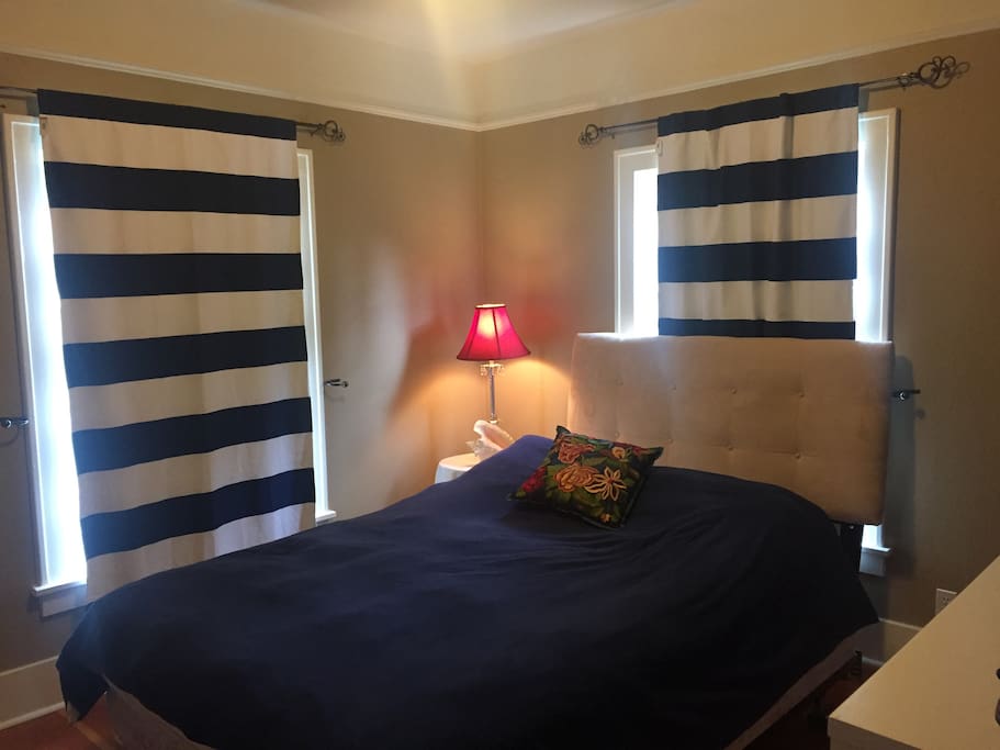 Extremely comfortable down comforter clad queen sized bed and blackout shades in the bedroom