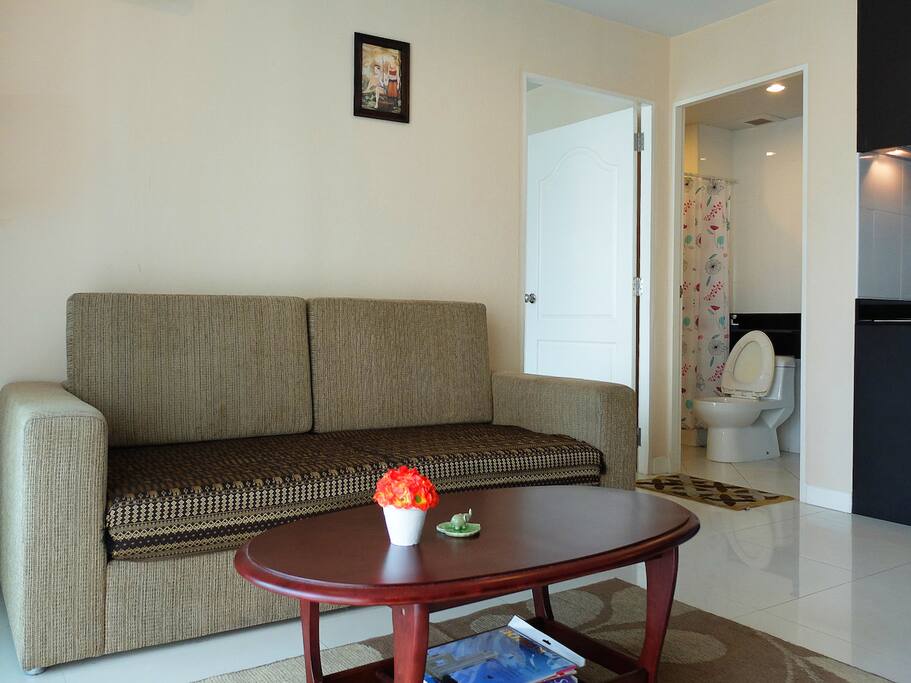 Big living room with sofa, TV, and balcony access