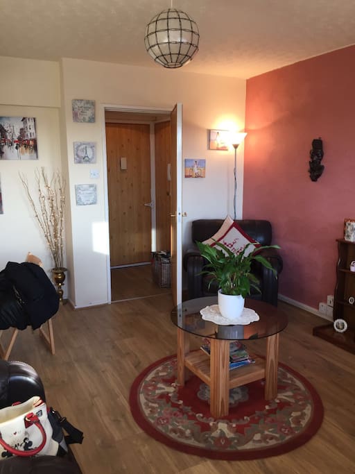 Living room with door leading to front door and stairs to upper level.