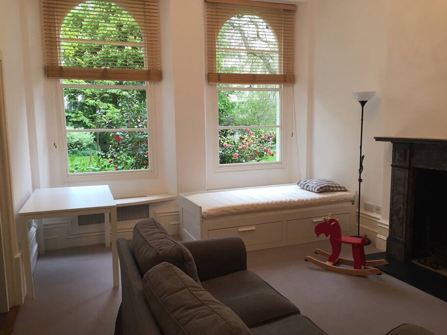 Living room overlooking the gardens with day bed, 2 couches, dining table, working fireplace