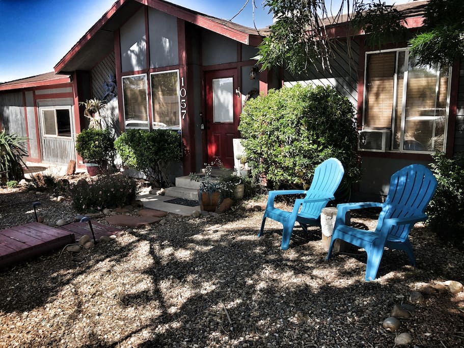 Front of house of Blue with shade trees and seating area