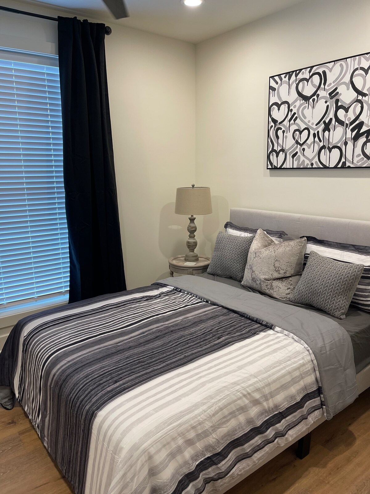 Chumba cha kulala cha kisasa chenye kitanda cha malkia kilichobuniwa kwa ajili ya kupumzika—vitani safi na mito mingi imejumuishwa.”
