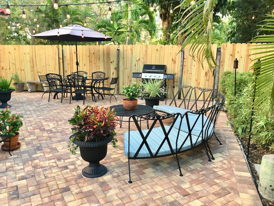 Shared paver patio with curved sofa and dining table that seats 8 with BBQ for convenience.