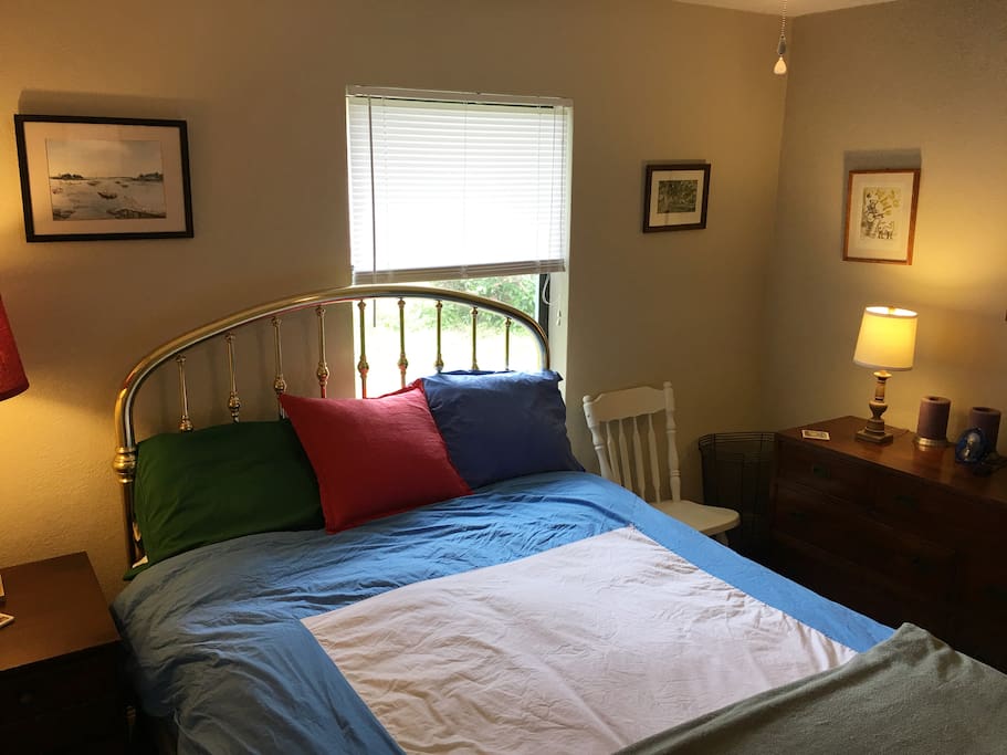 Bedside table, iron, ironing board, and full closet all your own