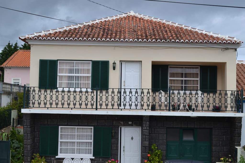 Fachada do apartamento e a varanda com mesa e cadeiras