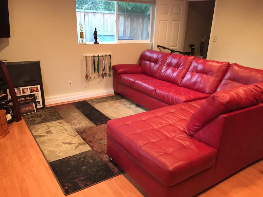 First room choice is a converted garage with sectional and workout equipment.