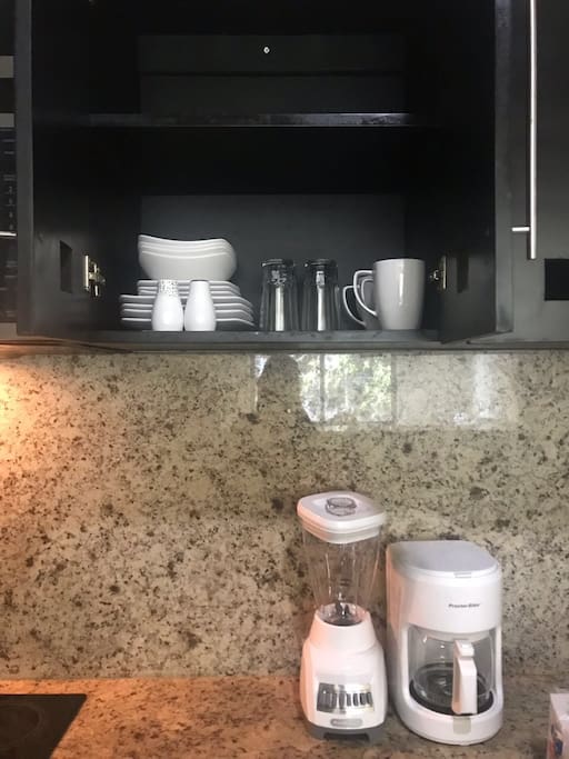 Mugs, glasses, plates, coffee maker and blender.