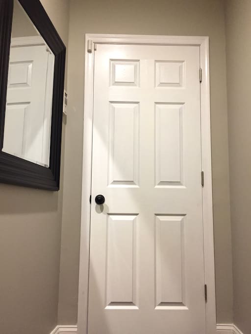 The private entrance to the lower level apartment complete with a mirror, coat hooks, and a security system for your comfort, convenience, and peace of mind.